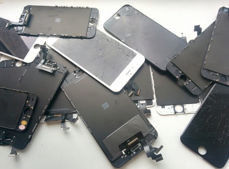 на фото множество разбитых экранов от айфонов