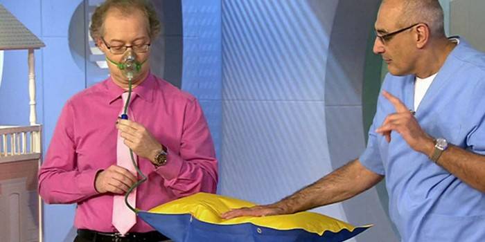 на фото врач демонстрирует как правильно использовать кислородную подушку