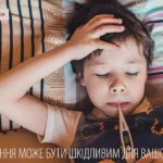 Дитині вимірюють температуру Зображення дитини, яка лежить у ліжку з закритими очима, тримаючи термометр у роті. Дитина поклала руку на лоб, що може свідчити про погане самопочуття. Зображення показує момент спокою та відпочинку під час хвороби, підкреслюючи важливість правильного догляду за дитиною.
